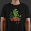 A person wearing a black t-shirt with a design of three carnivorous plants on the front